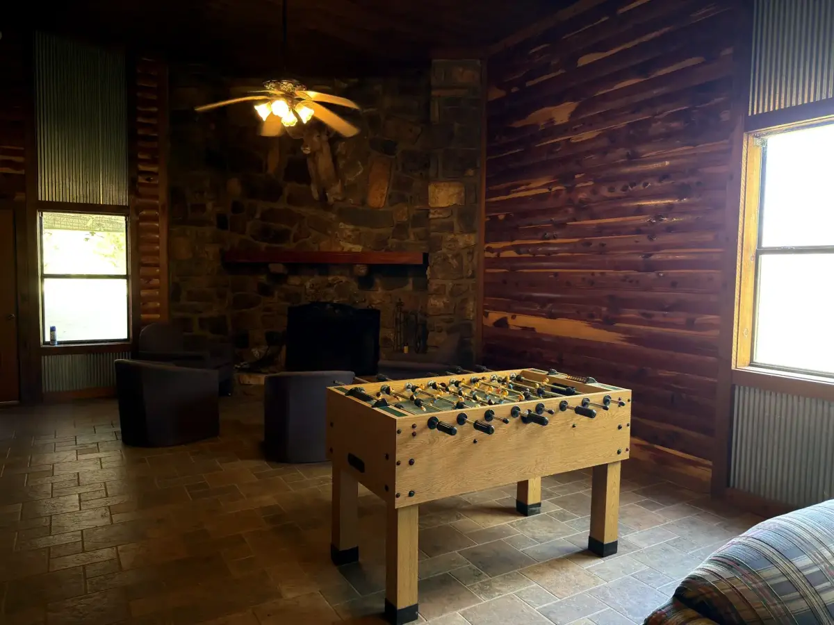 Activity room with foosball and stone fireplace in the Bunk House