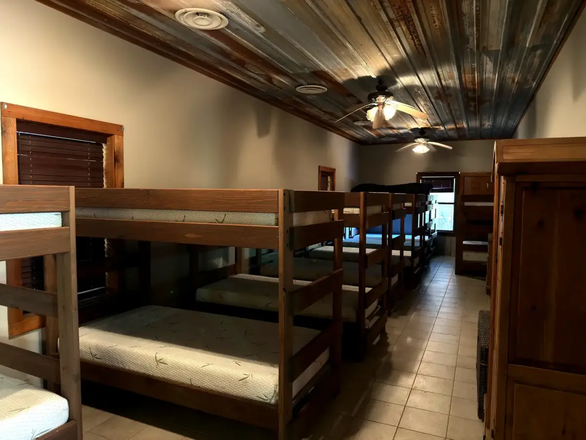 Bunk room with wood-paneled walls in the Bunk House