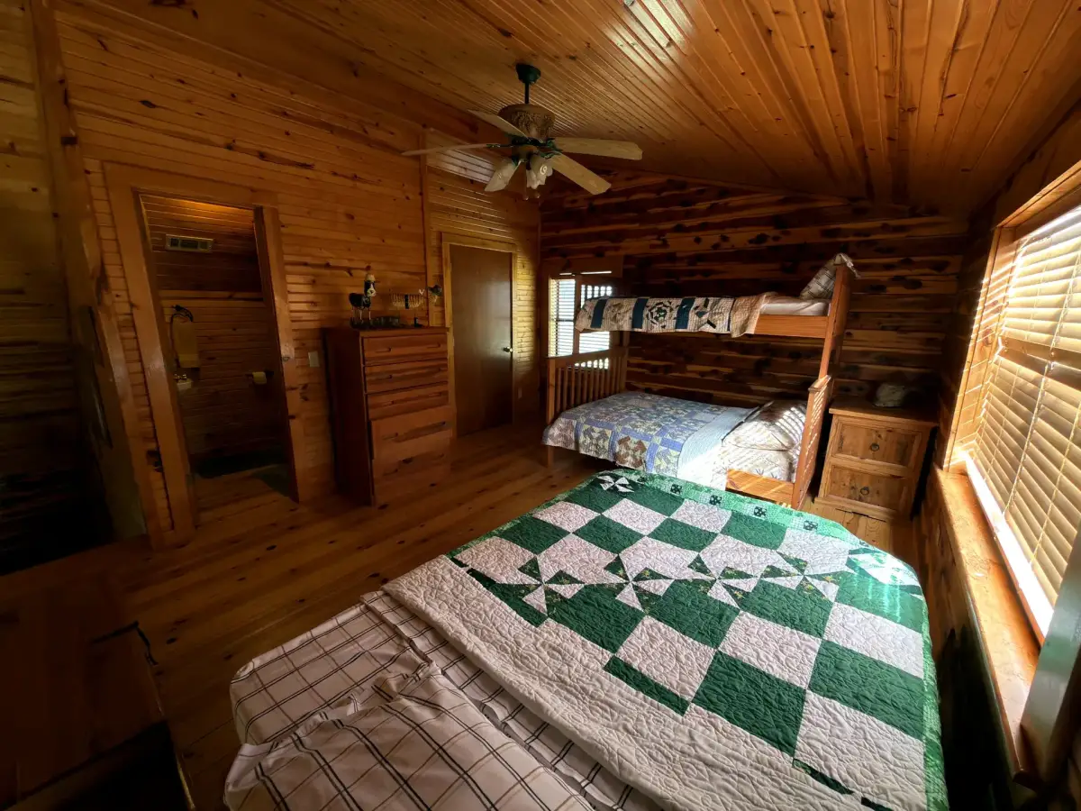 Upstairs bedroom with a bed and bunk beds in the Cabela Cabin