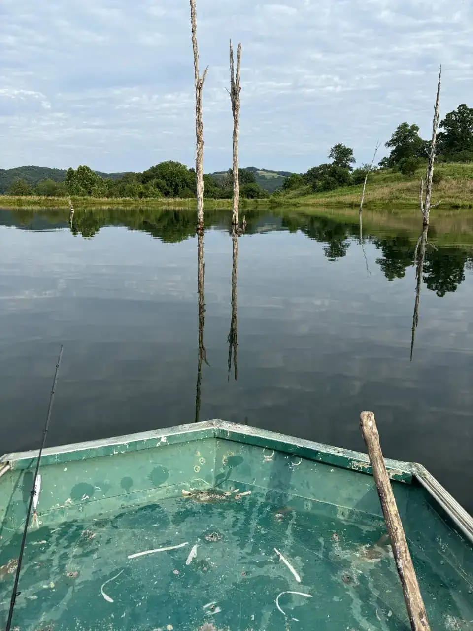 Fishing on a stocked pond at The Sanctuary Ranch in Arkansas, viewed from inside a flat-bottom boat